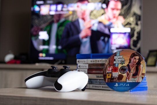 BRECHT, BELGIUM &ndash; August 28, 2026: Closeup portrait of a stack of PS5 games, a playstation controller, a physical game disc and a blurred home screen in the background.