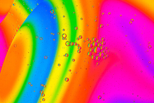 Colorful macro texture with oil and water bubbles on a rainbow background