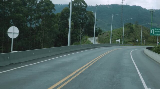 Empty Winding Mountain Road Through Forest with Signs, Video Recorded in 4K 24fps