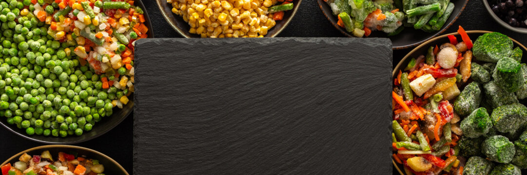 Organic, fresh fruits and vegetables frozen and prepared on a dark ebonite board, perfect for preserving the summer harvest and ensuring healthy, nutritious meals for the winter, banner