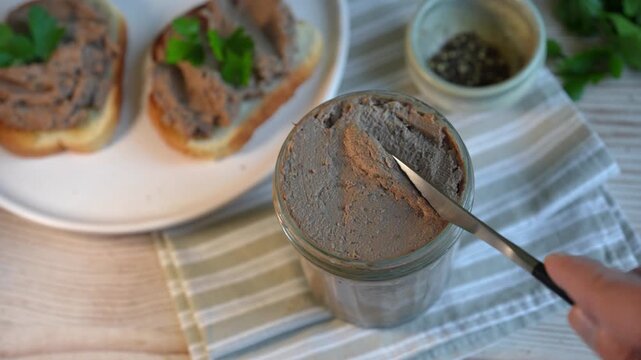 Homemade smooth liver pate in glass jar with toasted bread. Texture of healthy chicken liver pate.