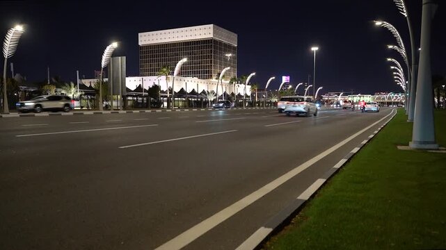 Doha, Doha Municipality, Qatar - 21 August 2026: View of a modern building at night with traffic moving along the illuminated road.