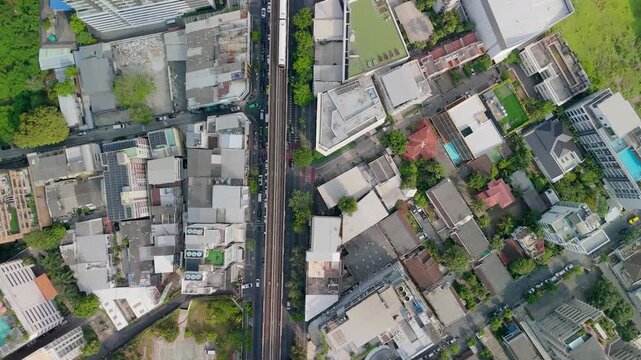 Top aerial view multilane urban road with central elevated rail track, surrounded by vehicles on both sides, showcasing modern city transportation infrastructure.
