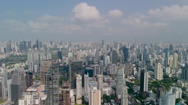 Aerial view of the central part of the Bangkok metropolis with dense and tall buildings and skyscrapers in the distance