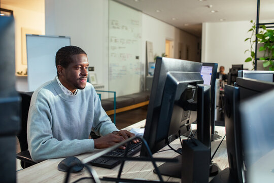 Business professional working at desktop computer in modern office workspace