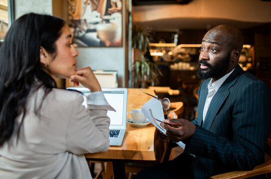 Business colleagues discussing documents in a cafe