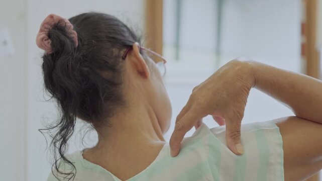 Asian senior woman use hand squeeze nape to relieves symptoms cramps, pain muscle, osteoporosis. Elderly female patient massages shoulder, arm for lifestyle healthcare, arthritis aches. Wellness 