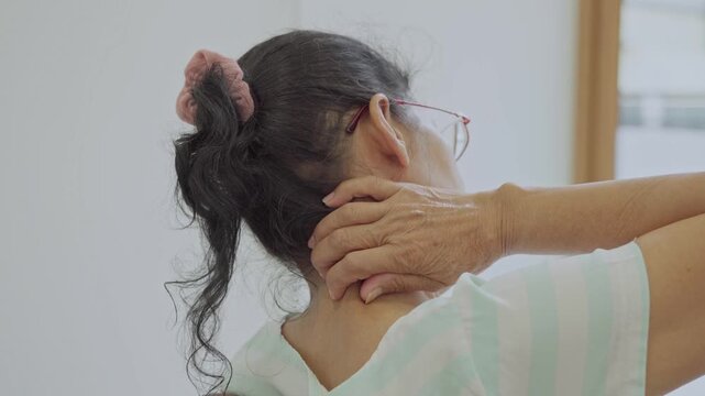 Asian senior woman use hand squeeze nape to relieves symptoms cramps, pain muscle, osteoporosis. Elderly female patient massages shoulder, arm for lifestyle healthcare, arthritis aches. Wellness 