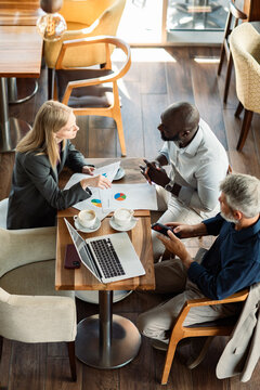 Business colleagues discussing sales charts in cafe