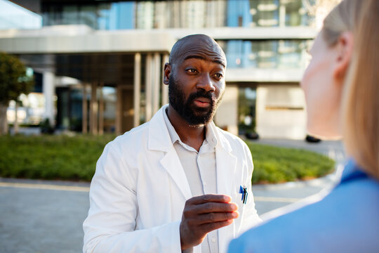 Male doctor discussing with colleague outside hospital