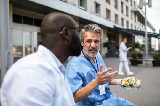 Doctors talking during lunch break outside hospital