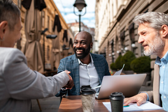 Colleagues sealing a business deal at an outdoor cafe