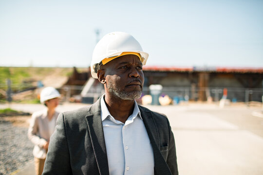 Senior construction manager wearing hard hat at outdoor construction site
