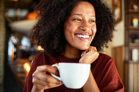 Smiling woman enjoying morning coffee at cafe