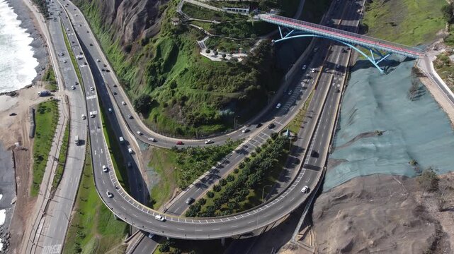Aerial view of cars driving on the curvy coastal highway interchange in miraflores, lima, peru