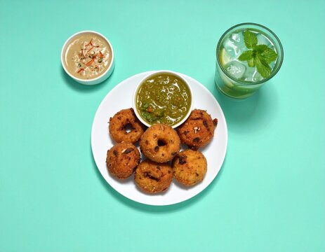Traditional South Indian snack Medu Vada served with chutneys and cold drink