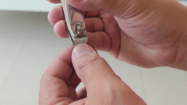Male grooming personal hygiene nail cutting care up-close light white model hands