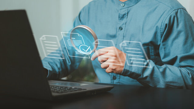 Audit, compliance checking, administrative review, verification, governance, and risk control. Professional using a magnifying glass to inspect digital documents on a laptop.