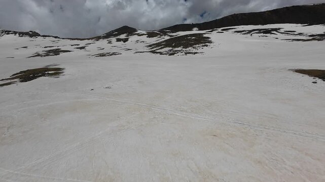 Aerial view of snowfields and cumulus clouds over Mount Aragats