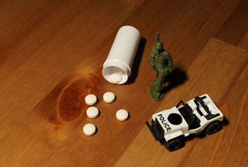 Pills, toy soldier, and police car representing drug war © Lovec1