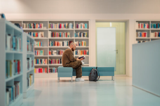 Man reading alone in a spacious quiet library