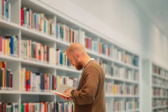 Man reading in a library with pastel blue shelves