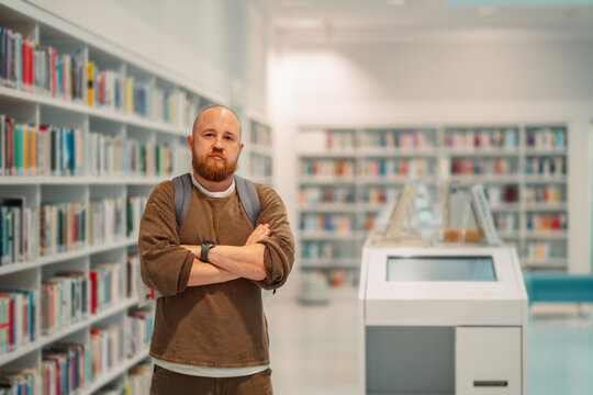 Man with crossed arms in a modern public library
