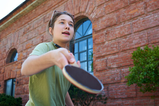 Teenager plays table tennis in a courtyard