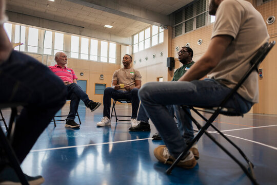 Diverse men forming a circle for group discussion or therapy