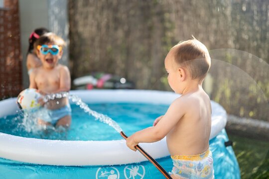 Children Playing In Inflatable Pool