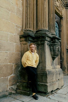 Man stands by stone wall in city center