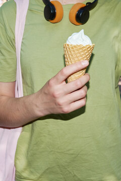 Anonymous teenager holding an ice cream in a cone