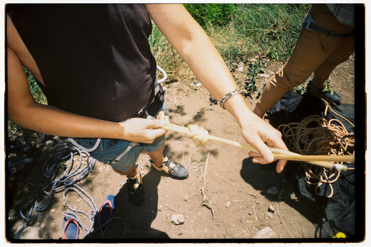Person Ties a Knot While Climbing 