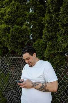 Candid portrait of a smiling tattooed man checking his phone