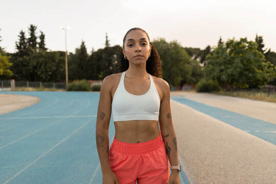 Young biracial woman standing on running track