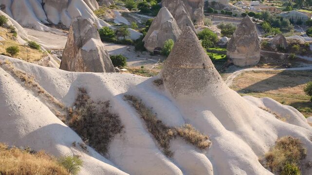 High angle view of unique volcanic tuff cones and fairy chimneys in Cappadocia Goreme valley under sunny sky. Travel, geological tourism, wilderness vacation concept, famous landmarks exploration