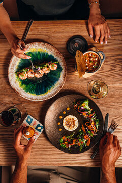 Overhead view of guests dining and sharing Spanish tapas