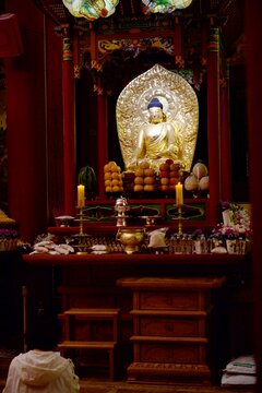 Golden Buddha statue in a colorful traditional Korean temple