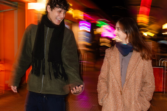 Dynamic, fun portrait of couple walking down the street