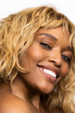 Woman With Blonde Curly Hair Smiling Indoors