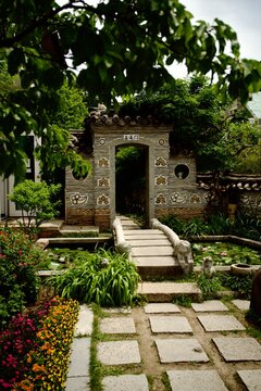 Traditional garden gate with a stone bridge over a pond
