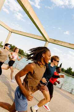 Wide shot of athletes training by a lake with a distorted horizon