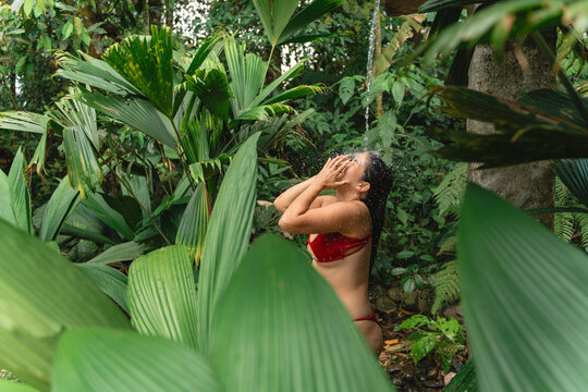 Individual enjoying outdoor shower in lush rainforest