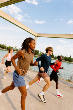 Young athletes train by a lake at sunrise in a distorted wide shot