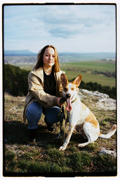 Film photo of a woman with her cute dog having a walk in the mountains