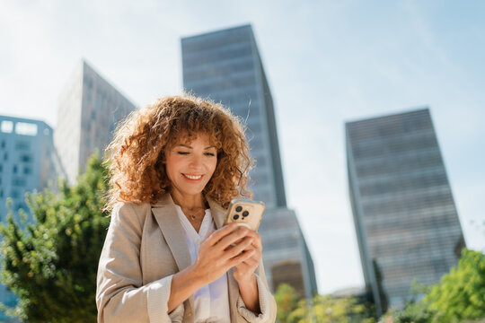 Businesswoman Texting on Smartphone While Walking in City Park