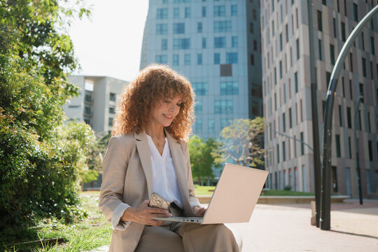 A woman making a video call on a Laptop in an Urban Park