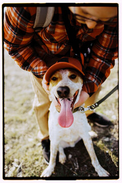 Film photo of happy man having fun with his cute dog, hugging him 
