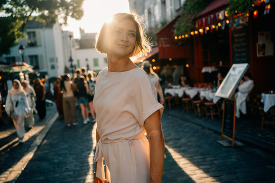 Woman Walks Through a Street in a Busy Area During Sunset