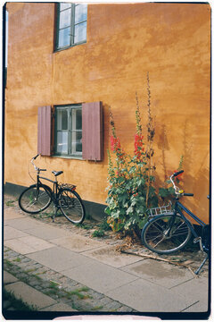 Analog medium shot of bikes parked by a Copenhagen house in the sun